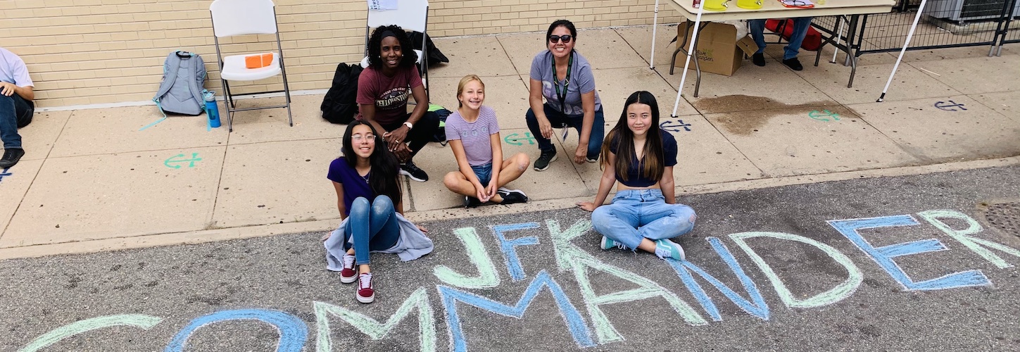 Group of students posing with chalk art for Commander Pride